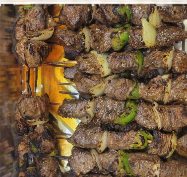 Beef kabob skewers with onion and green pepper on the charcoal grill