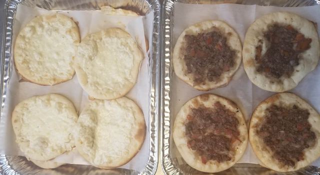 Catering trays of mini cheese manakish and mini meat pies (lahm bi ajeen)