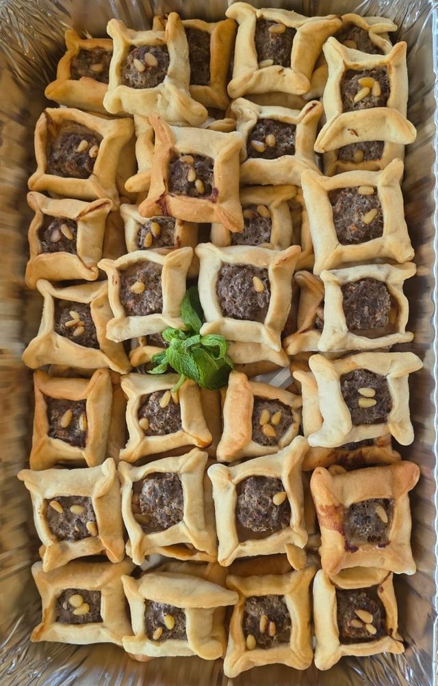 Tray of square meat pies topped with pine nuts