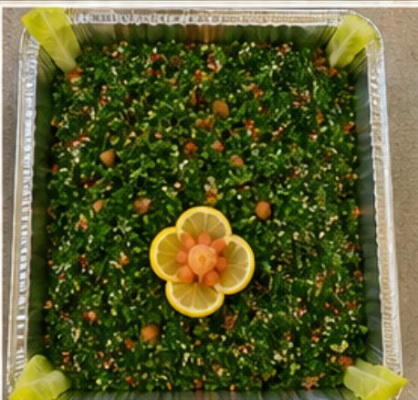 Catering tray of tabbouleh salad garnished with lemon